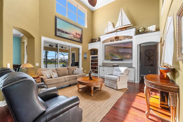 3583 Valleyview Dr, Kissimmee, FL 34746 - living room with crown molding, a ceiling fan, a towering ceiling, arched walkways, and dark wood finished floors