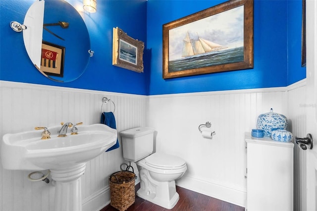 3583 Valleyview Dr, Kissimmee, FL 34746 - half bathroom featuring a sink, wood finished floors, toilet, and wainscoting