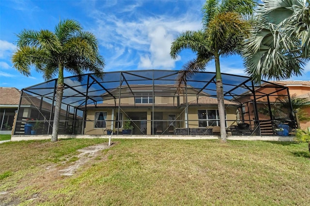 3583 Valleyview Dr, Kissimmee, FL 34746 - rear view of property with a lawn, stucco siding, and glass enclosure