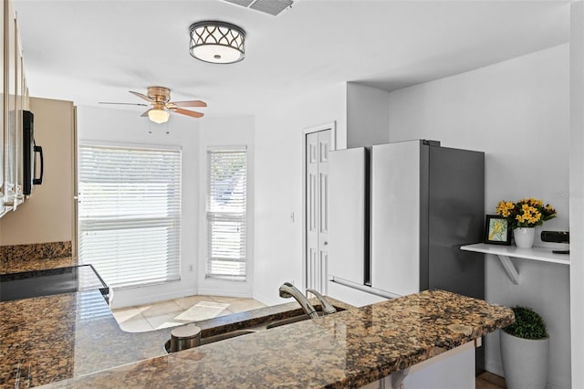 9301 Echo Run, Orlando, FL 32817 - kitchen featuring ceiling fan, freestanding refrigerator, a sink, and dark stone countertops