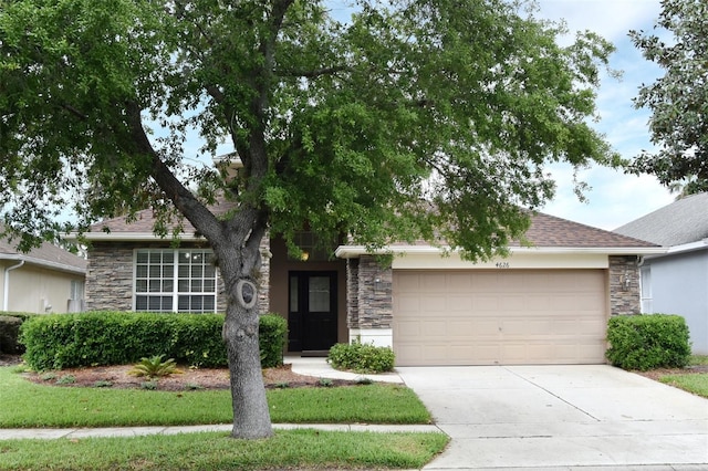4626 Redmond Pl, Sanford, FL 32771 - view of front of house featuring driveway, a garage, stone siding, and roof with shingles
