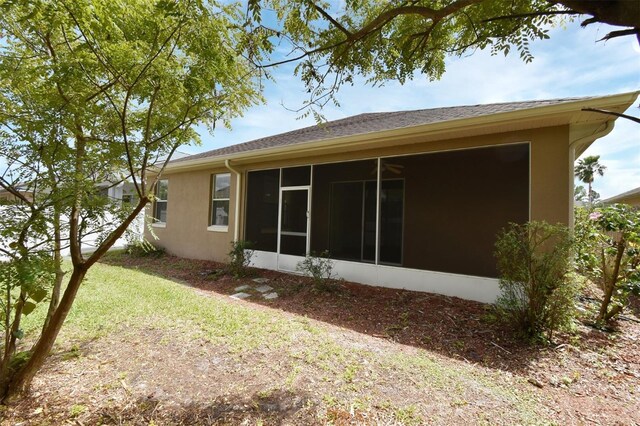 4626 Redmond Pl, Sanford, FL 32771 - rear view of property featuring a sunroom, a lawn, and stucco siding