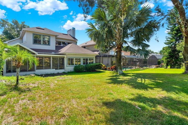 738 Powderhorn Cir, Lake Mary, FL 32746 - rear view of house featuring a chimney, a shingled roof, glass enclosure, and a lawn