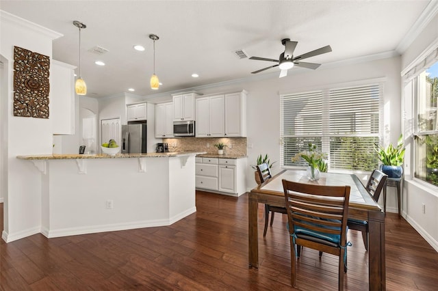7837 Bostonian Dr, Winter Garden, FL 34787 - kitchen with crown molding, backsplash, white cabinets, and appliances with stainless steel finishes