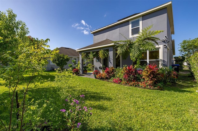 7837 Bostonian Dr, Winter Garden, FL 34787 - back of house with a lawn, stucco siding, and a patio
