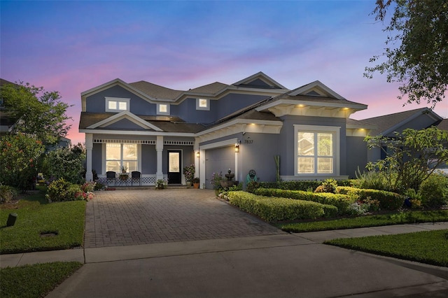 7837 Bostonian Dr, Winter Garden, FL 34787 - view of front of property featuring a garage, decorative driveway, stucco siding, and covered porch