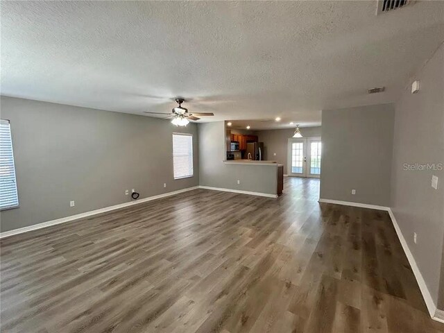 interior space featuring dark wood-type flooring, visible vents, baseboards, and ceiling fan