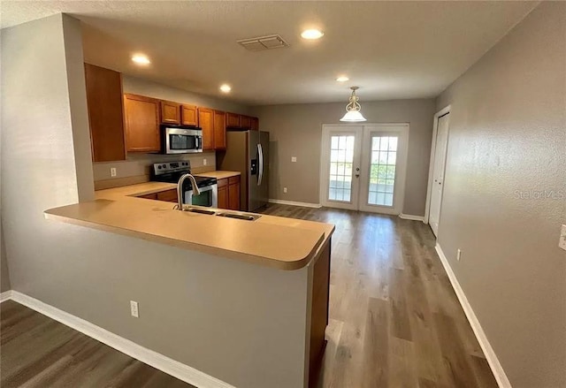 kitchen featuring brown cabinetry, visible vents, light countertops, stainless steel appliances, and french doors