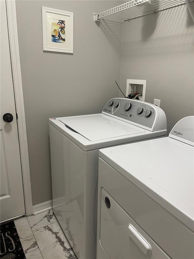 laundry room with marble finish floor, separate washer and dryer, and laundry area