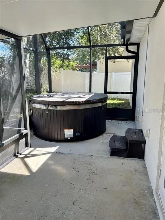 unfurnished sunroom with a hot tub