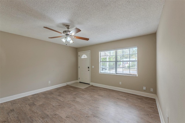 entryway featuring a textured ceiling, a ceiling fan, and wood finished floors