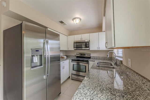 kitchen featuring visible vents, white cabinets, a sink, appliances with stainless steel finishes, and light stone countertops
