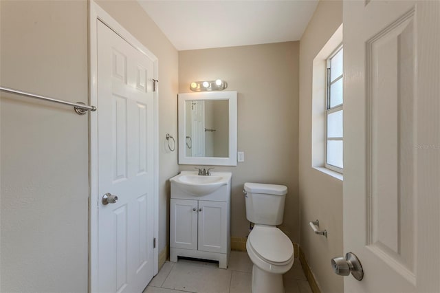bathroom with tile patterned floors, vanity, baseboards, and toilet