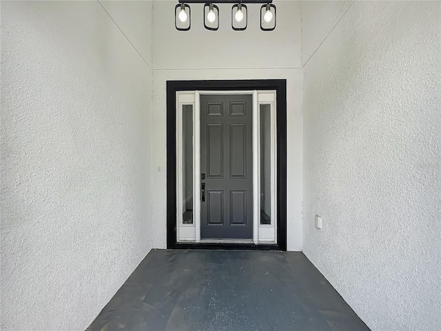 view of exterior entry featuring stucco siding
