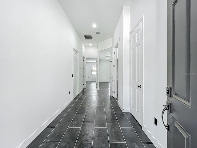 corridor featuring baseboards and visible vents