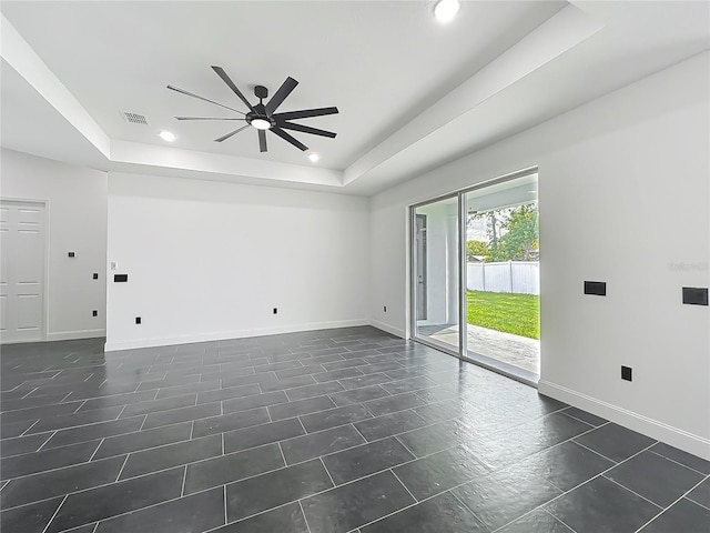 empty room with visible vents, baseboards, a raised ceiling, ceiling fan, and recessed lighting