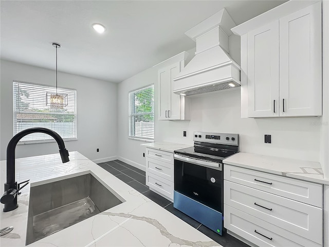 kitchen with stainless steel electric range, premium range hood, white cabinets, a sink, and hanging light fixtures
