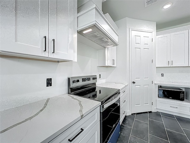 kitchen with custom exhaust hood, visible vents, white cabinets, stainless steel range with electric cooktop, and light stone counters