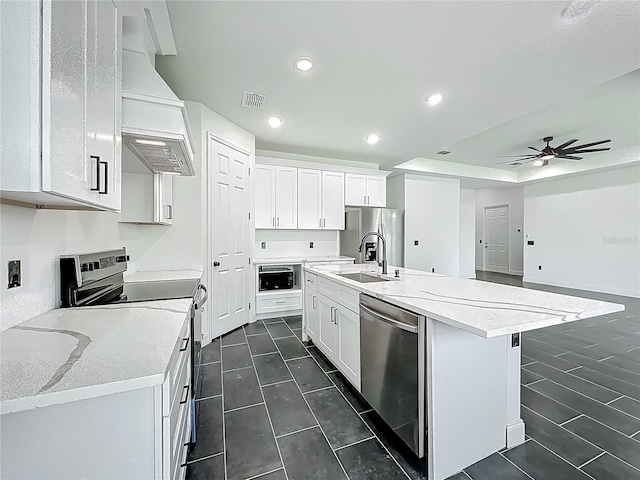 kitchen with premium range hood, a sink, white cabinetry, and stainless steel appliances