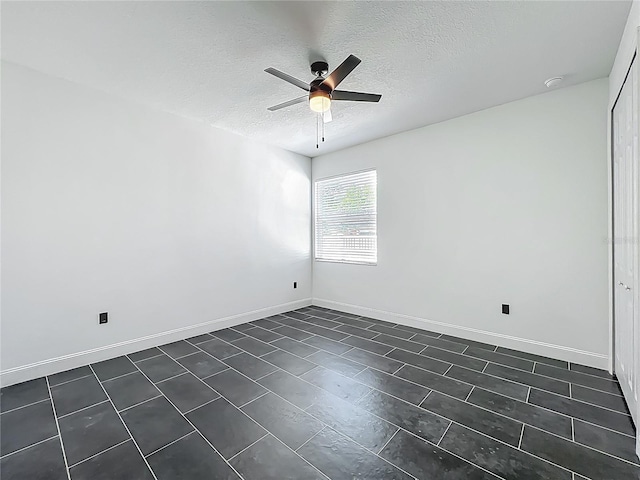 unfurnished room with ceiling fan, baseboards, and a textured ceiling