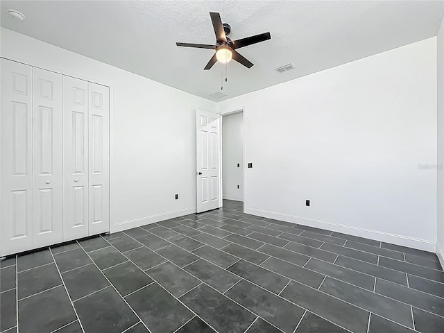 unfurnished bedroom with visible vents, baseboards, a closet, a ceiling fan, and a textured ceiling