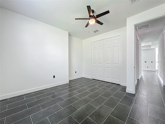 unfurnished bedroom with a closet, baseboards, a ceiling fan, and visible vents