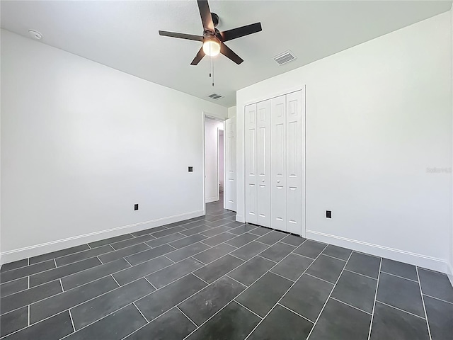 unfurnished bedroom featuring a closet, ceiling fan, baseboards, and visible vents