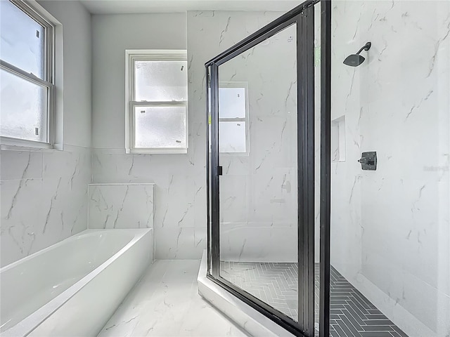 full bathroom featuring marble finish floor, a bath, and a marble finish shower