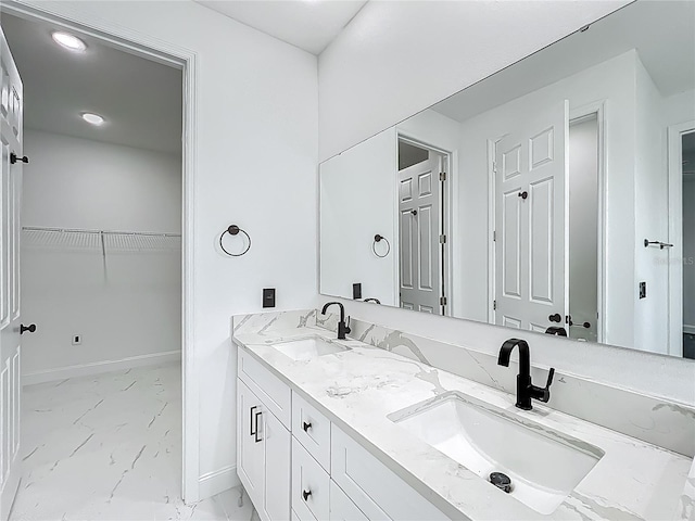 bathroom featuring a sink, baseboards, and marble finish floor