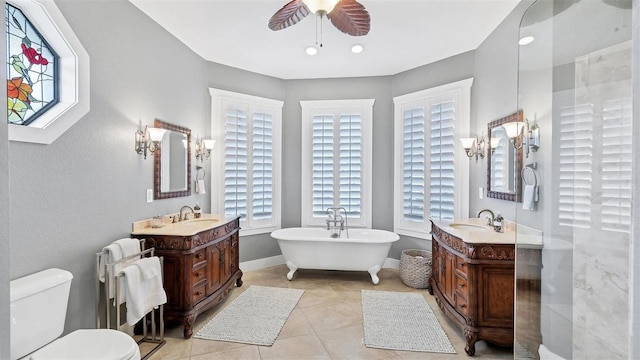 full bathroom with a healthy amount of sunlight, ceiling fan, and a sink