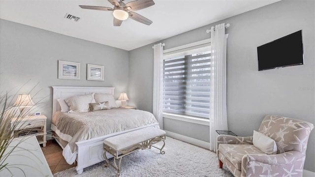 tiled bedroom featuring visible vents, ceiling fan, multiple windows, and baseboards