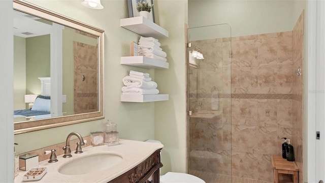 bathroom featuring visible vents, toilet, a shower stall, and vanity