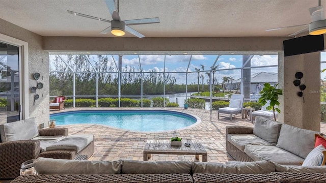 pool featuring a patio area, an outdoor living space, glass enclosure, and a ceiling fan