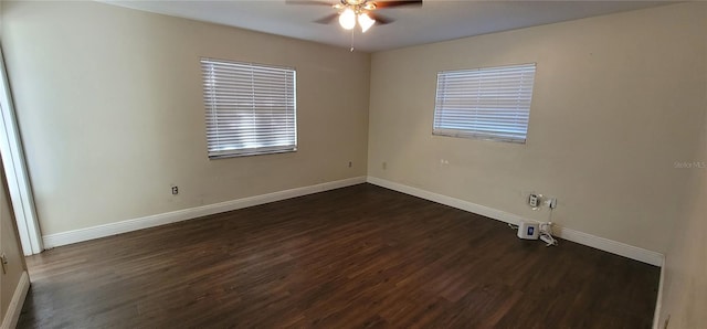 unfurnished room featuring dark wood-type flooring, a healthy amount of sunlight, a ceiling fan, and baseboards