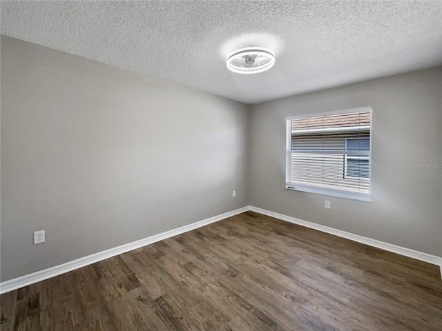 unfurnished room featuring baseboards, a textured ceiling, and dark wood-style floors