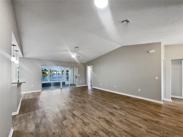 unfurnished living room featuring baseboards, wood finished floors, and vaulted ceiling