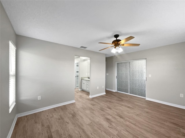 unfurnished bedroom with light wood-type flooring, baseboards, and multiple windows