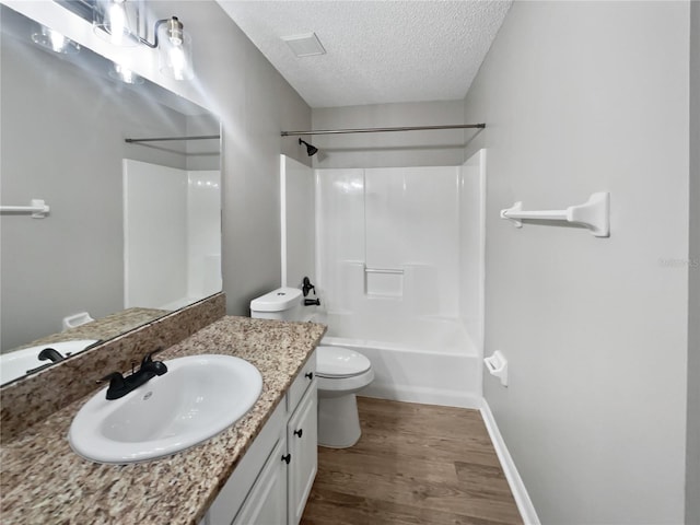bathroom with visible vents, toilet, a textured ceiling, vanity, and wood finished floors