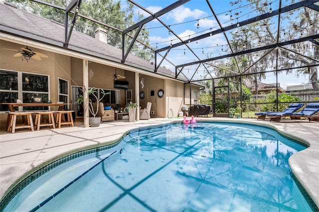 pool with outdoor lounge area, a patio area, a ceiling fan, and a lanai