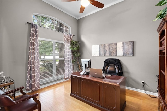 office area featuring light wood-style floors, ceiling fan, crown molding, and baseboards