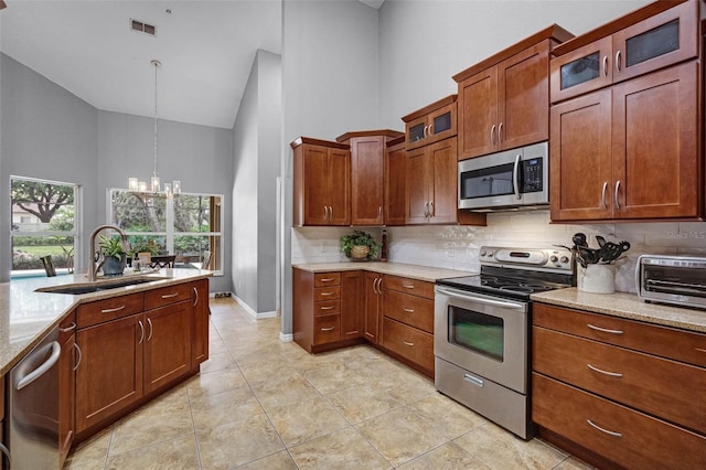 kitchen with backsplash, visible vents, appliances with stainless steel finishes, high vaulted ceiling, and a sink