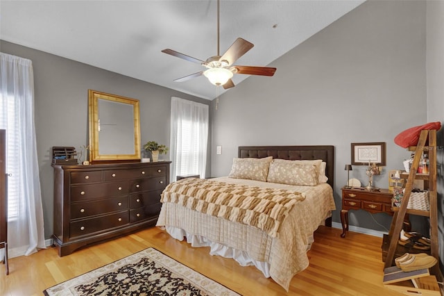 bedroom featuring baseboards, light wood-type flooring, ceiling fan, and lofted ceiling