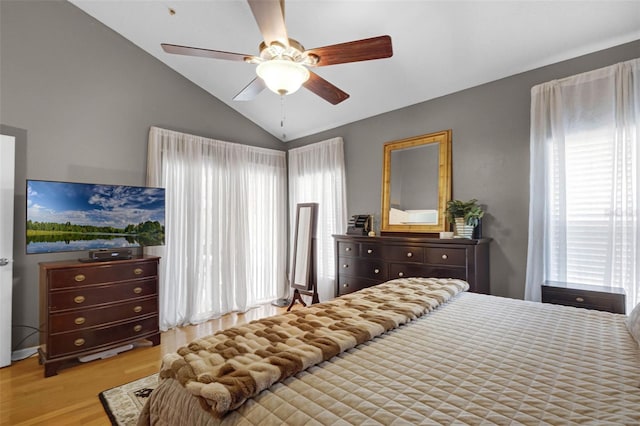 bedroom with a ceiling fan, wood finished floors, multiple windows, and lofted ceiling