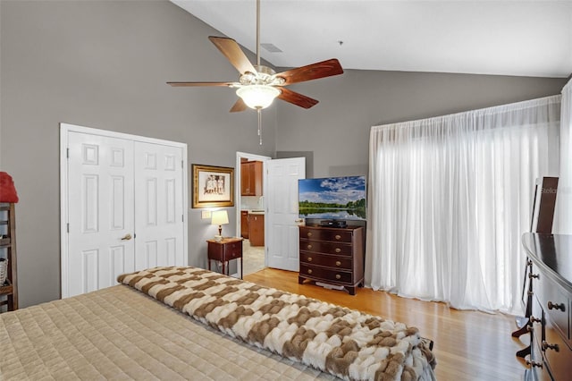 bedroom with a closet, light wood-type flooring, high vaulted ceiling, and ceiling fan