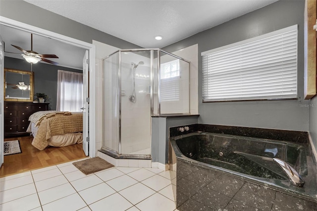 ensuite bathroom featuring a stall shower, a garden tub, a ceiling fan, and tile patterned floors