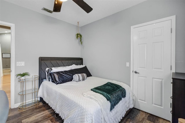 bedroom with visible vents, ceiling fan, wood finished floors, and baseboards