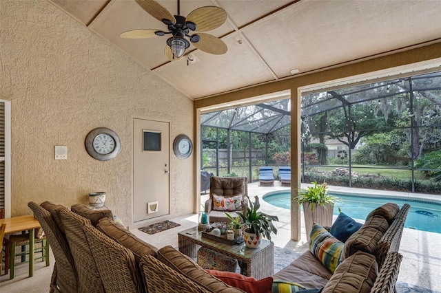 living area with a textured wall, ceiling fan, a sunroom, and vaulted ceiling
