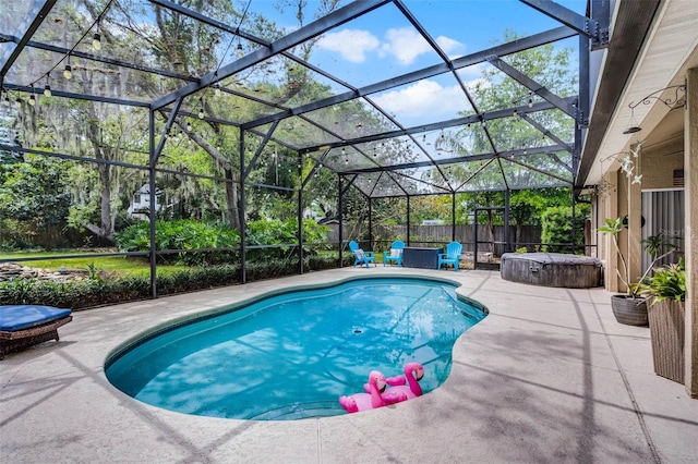 pool with a patio area, a fenced backyard, glass enclosure, and a hot tub