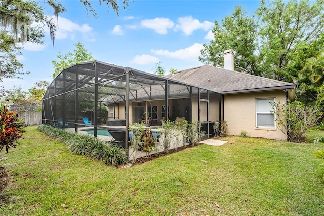 rear view of house with roof with shingles, stucco siding, a chimney, glass enclosure, and a lawn