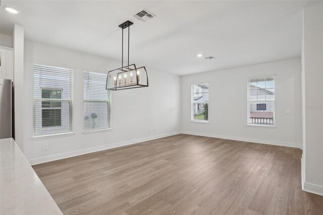 16484 Silver Brook Way, Winter Garden, FL 34787 - unfurnished dining area with light wood finished floors, baseboards, a chandelier, and recessed lighting